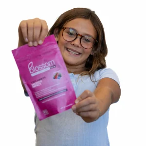 child holding blossom gum bag smiling